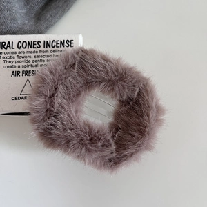 Detailed macro view of soft faux rabbit fur texture on a smoke grey plush hair claw clip