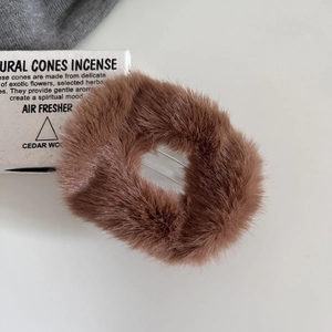 Close-up of brown plush hair claw clip featuring soft faux fur for autumn winter styles