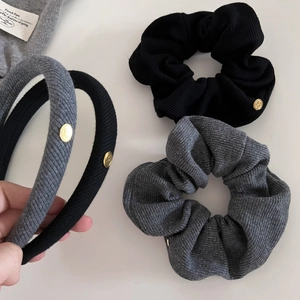 Set of black and grey ribbed knit headbands and scrunchies with golden metal tags