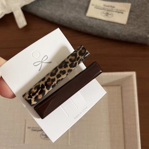 Dettaglio ravvicinato di fermagli per capelli con stampa leopardata e resina marrone
