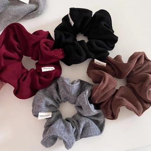 Macro detail of knit texture on handmade scrunchies in wine red and dark gray colors