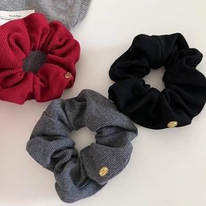 Three-pack of ribbed knit scrunchies in red, black, and grey with elegant gold metal tags
