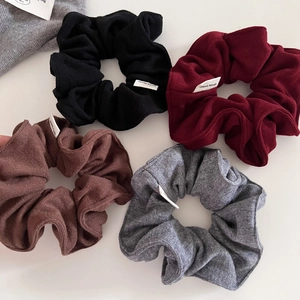 Close-up of ribbed knit scrunchies set in black, burgundy, coffee, and grey colors