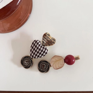 Detail view of retro French style hair clips with houndstooth heart and rhinestone accents
