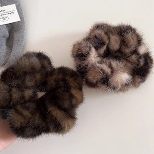 Close-up of soft leopard print faux fur scrunchies with fluffy texture for autumn winter