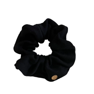 Chic black ribbed knit scrunchie hair tie with elegant oval golden metal logo tag