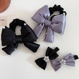Gros plan de chouchous en satin noir et gris avec strass et pinces à fleurs en perles