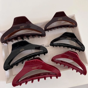 Elegant French acetate hair claws in dark brown, black, and burgundy on a grey tray