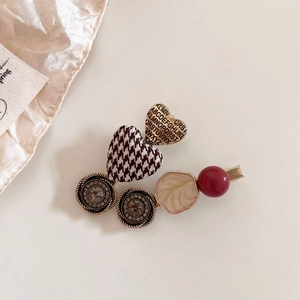 Detail of vintage French style hair clip with houndstooth heart and gold alphabet charm