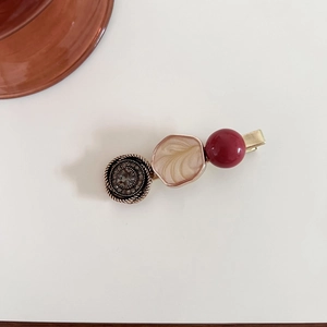 Detailed close-up of retro French hair clip with marble texture and rhinestones