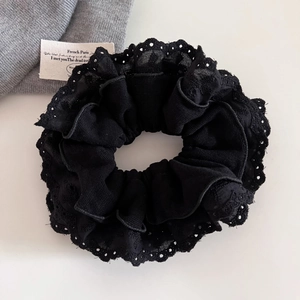 Detail of black lace hair scrunchie with polka dot hollow edges and soft vintage texture