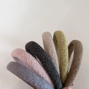 Thick plush lamb wool headbands in various muted colors displayed in a fan arrangement