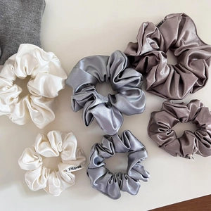 Chouchous élégants en satin de soie crème et gris argenté montrant la texture du tissu