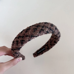 Gros plan détaillé d'un serre-tête en tweed fait main avec texture marron et doublure