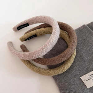 Detail of plush lamb wool headbands with handmade labels in earthy color tones