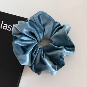 Dettaglio dell'elastico in velluto blu scuro con trama morbida e design a pieghe