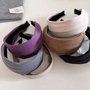 Detailed texture of assorted velvet padded headbands in purple, beige and grey