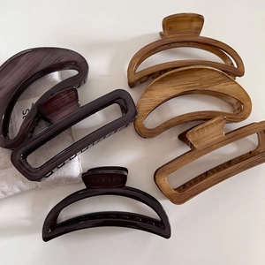 Detail view of five assorted marble and wood grain hair claws in semi-circle and square shapes