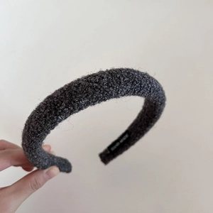 Detailed close-up of dark grey lambswool headband showing handmade label and plush texture
