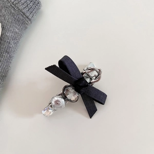 Dettaglio del fermaglio a fiocco in seta con cristalli di zircone grigio decorati