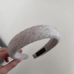 Close-up of thick grey wool headband showing knitted texture and soft fabric detail