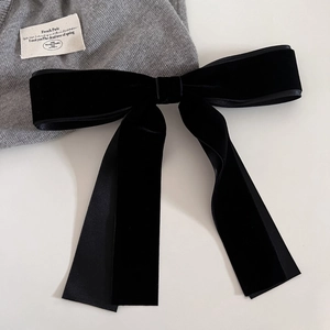 Detailed view of the black velvet bow hair clip with long ribbons and satin edges