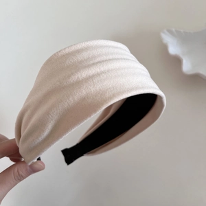 Detailed view of the thick pleated cloud-style headband in cream white fabric texture