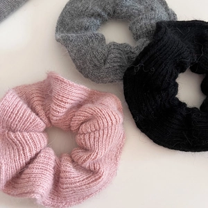 Three-piece set of knitted wool scrunchies in pink, grey, and black colors for women