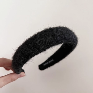 Detailaufnahme des schwarzen Plüsch-Haarreifs mit weichem Fell und Handmade-Etikett