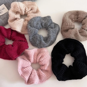 Close-up of fluffy knitted scrunchies in six colors with soft mohair texture