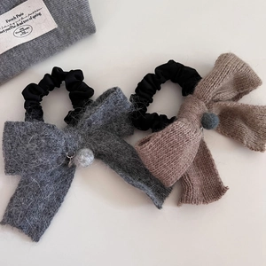 Détail de chouchous nœuds en peluche et tricot avec pompons doux aux couleurs d'automne