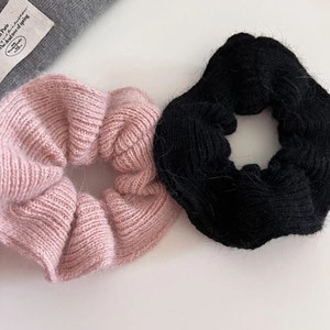 Close-up of knit scrunchies in pink and black colors with soft mohair texture