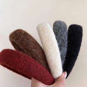 Detail showing five thick wool headbands in wine red, brown, beige, gray and black