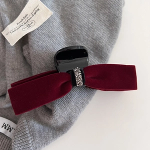 Dettaglio della pinza per capelli in velluto rosso con cerchio di strass argentati lucidi
