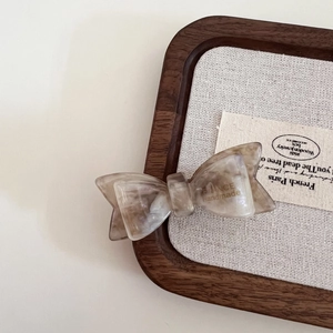 Detailed macro view of an elegant marble grey acetate bow hair clip with handmade textures