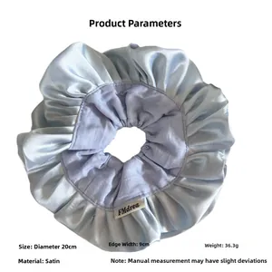 Macro detail of 20cm light blue satin scrunchie with layered ruffles and smooth texture