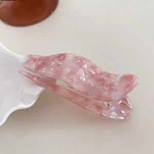 Macro shot of large pink marble acetate hair claw with France handmade engraving