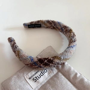 Détail du serre-tête en tweed avec étiquette fait main montrant la texture tissée
