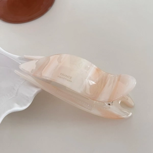Detailed macro view of acetate hair clip featuring marble texture and France Handmade text