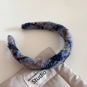 Gros plan du serre-tête rétro en tweed à carreaux avec détails de texture tricotée