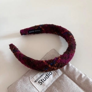 Gros plan d'un serre-tête rétro en tweed rembourré avec texture tissée et étiquette main