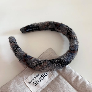 Gros plan du serre-tête rétro en tweed fait main avec fibres grises et noires texturées