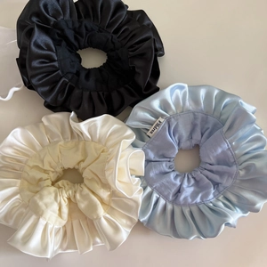 Three oversized satin scrunchies in black, cream, and light blue with pleated ruffles