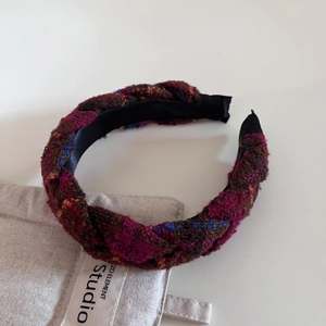 Détail d'un serre-tête en tweed à carreaux rétro avec texture tressée et design haut