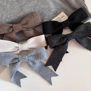 Détail de pinces à cheveux à nœuds tricotés en cinq couleurs terre avec rubans souples
