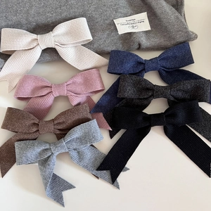 Détails de la texture tricotée des pinces à cheveux nœud en beige, rose et autres