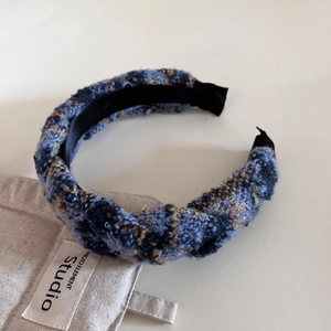 Détail du serre-tête en tweed bleu et marron avec doublure en satin sur du lin