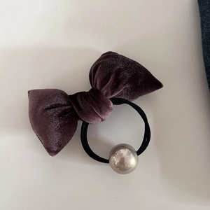 Detail of dark purple velvet bow scrunchie with a reflective mirror metal ball accent