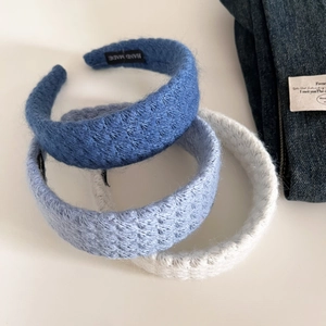 Three-piece set of knitted headbands in navy, grey blue, and cream with handmade label