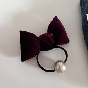 Detail of purple velvet bow hair tie with large metallic pearl bead and black elastic band